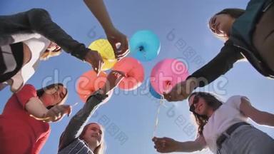 一群朋友向天空<strong>释放</strong>五颜六色的<strong>气球</strong>。